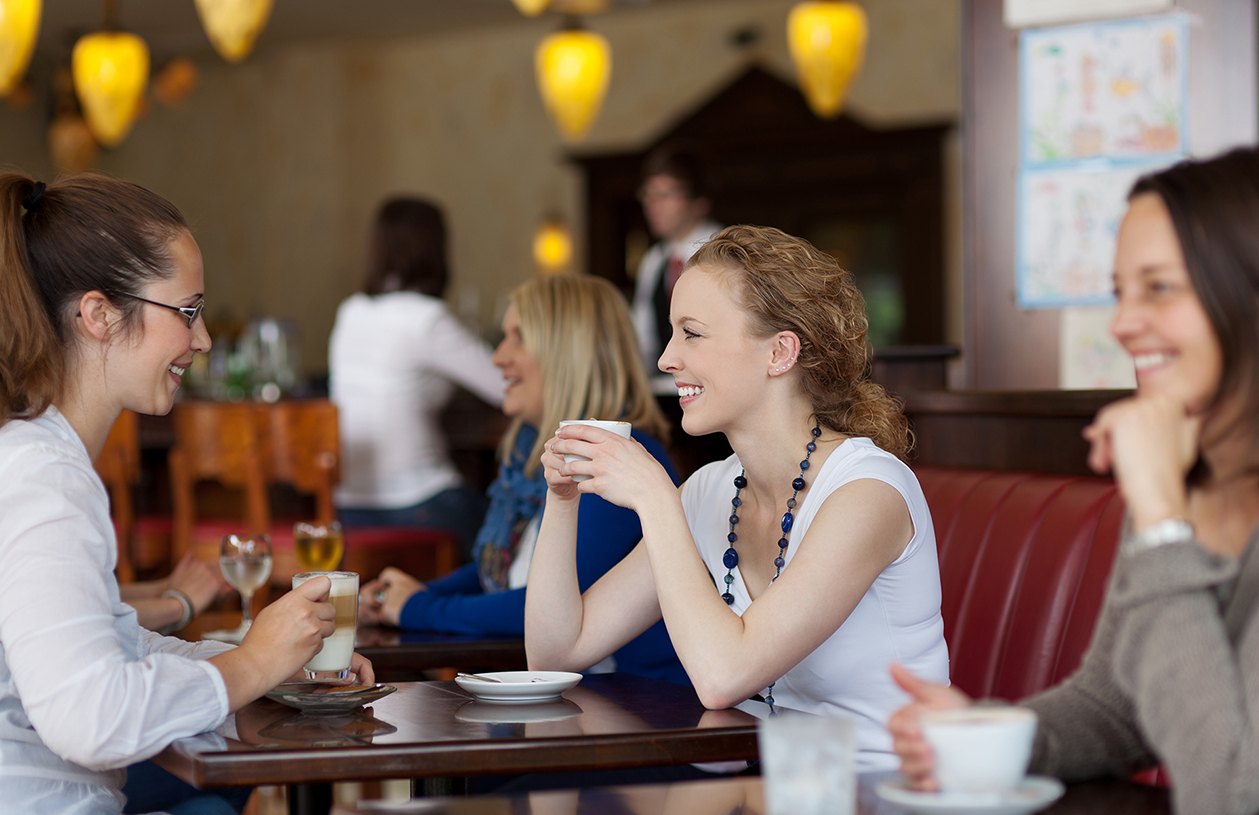 Первое общение в истории. Люди в кафе. Человек с кофе. Люди сидят в кафе. Люди за столиком в кафе.